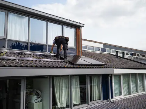 A roofer at work on the roof of a house