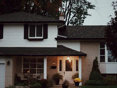 A two-story house with a pitched shingle roof