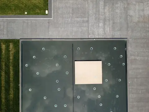 A flat roof covered in dark membrane, seen from above