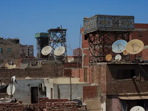 Brick rooftops with parapets, water tanks and satellite dishes