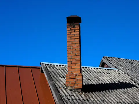 A brick chimney against a deep blue sky