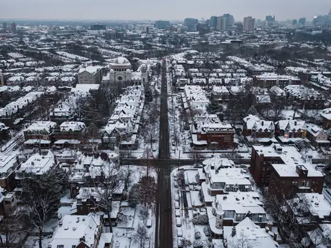 Rows of attached houses under snow, seen from the air